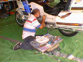 Ray Herro painting on a motorcycle